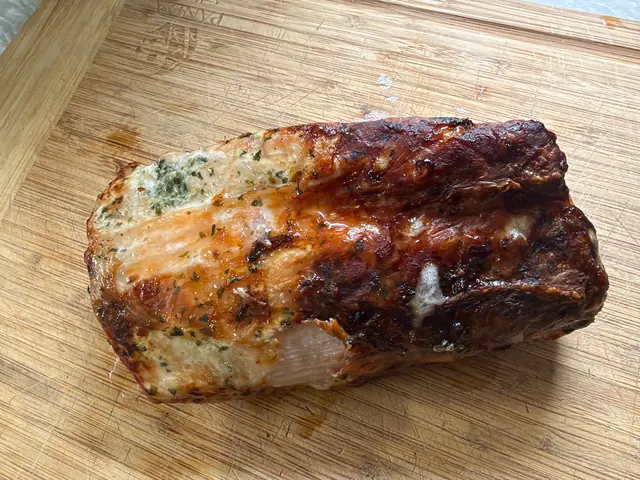The browned pork loin resting on a cutting board