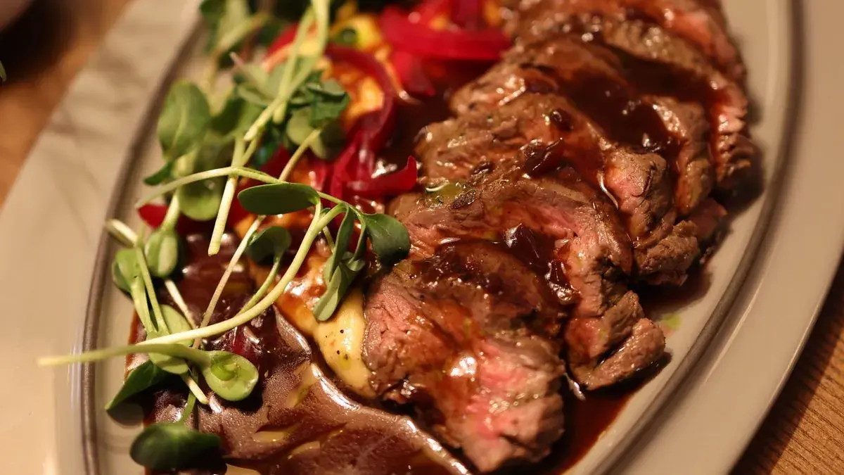 Thinly sliced steak with pan sauce and microgreens