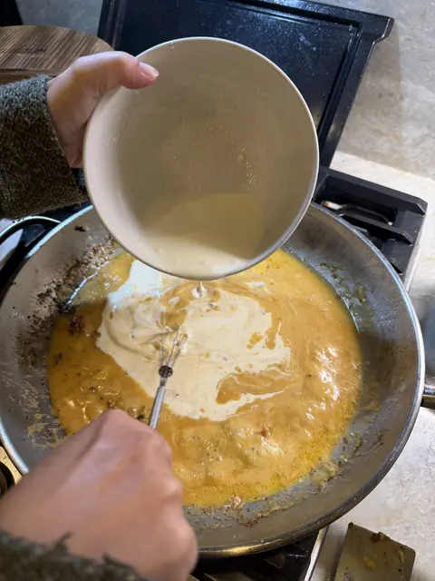 Pouring the cream into the skillet to make the sauce
