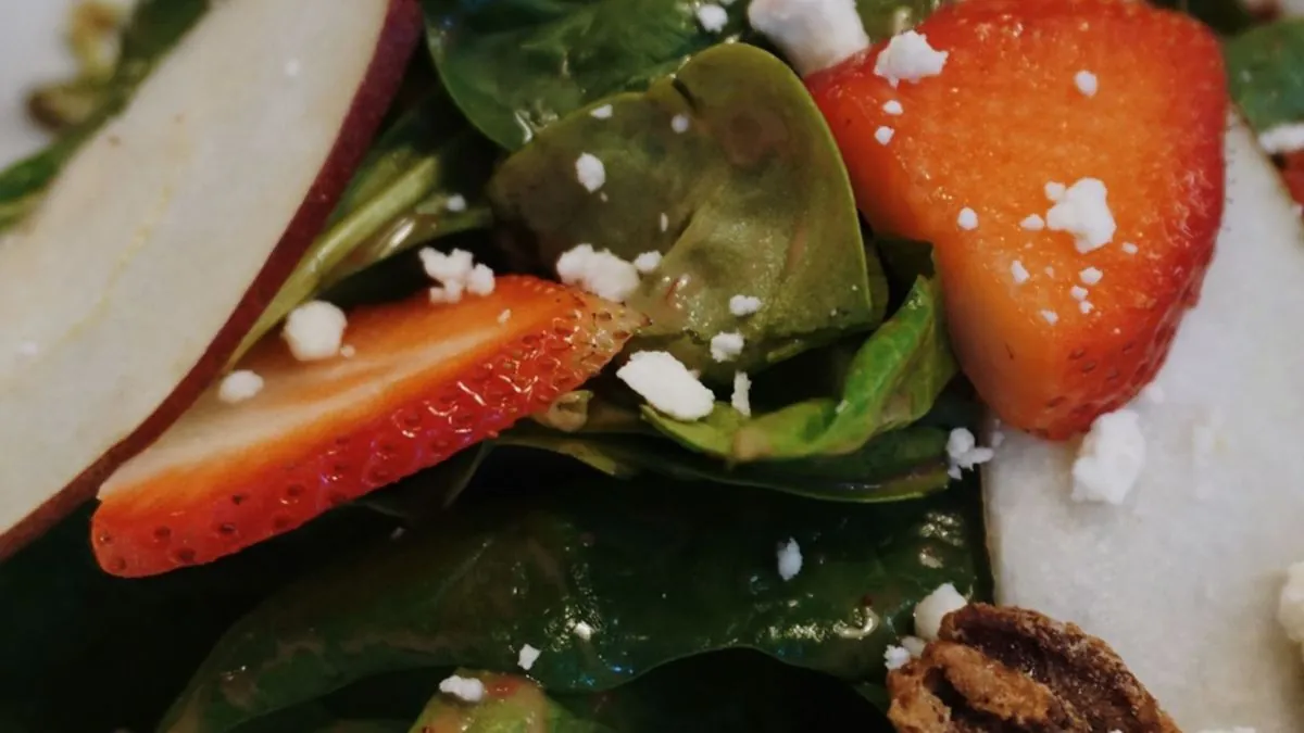 Spinach salad with strawberries, candied pecans and crumbled cheese