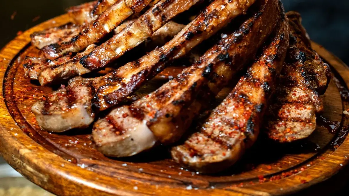 Grilled pork ribs stacked on a wooden board