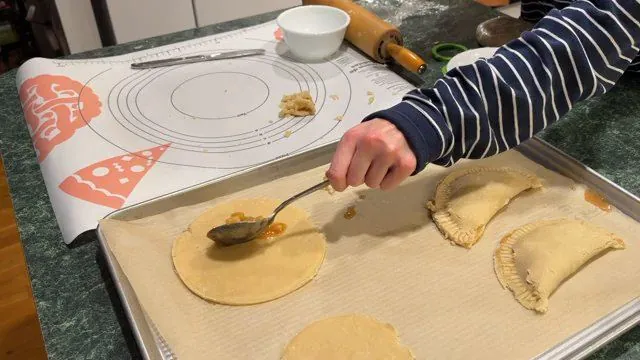 Filling the pastry rounds and folding them into turnovers