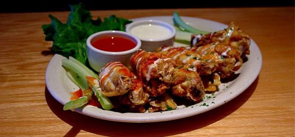 Chicken wings with hot sauce, ranch dip and celery
