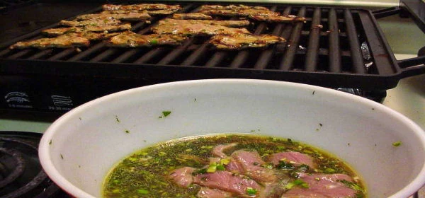 Marinated beef beside a tabletop grill