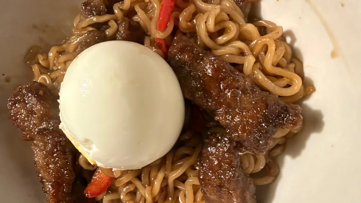 Korean beef ramen with seared flank steak strips, ramen noodles and sweet red pepper, topped with a semi-hard-boiled egg