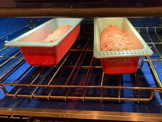 Two meat loaves in loaf pans going into the oven
