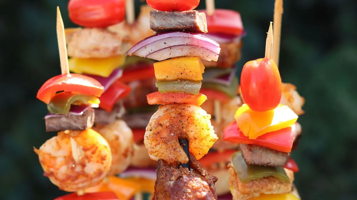 Grilled skewers of meat, shrimp, peppers, onion and tomatoes