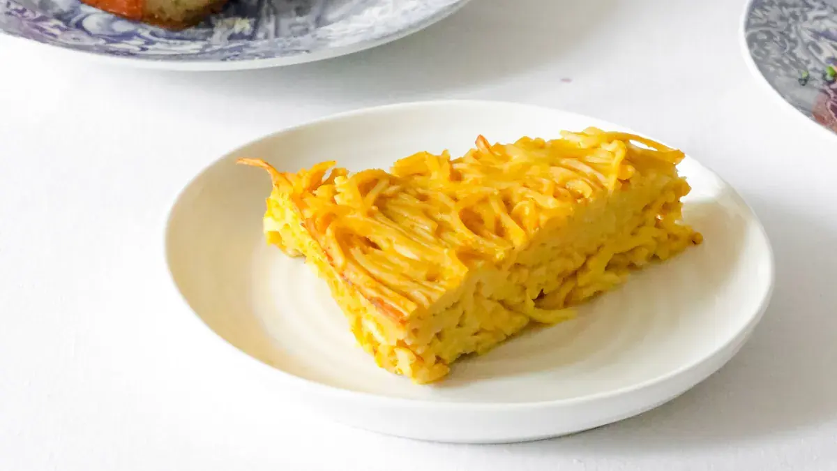 Slice of sweet noodle kugel on a plate at a holiday table