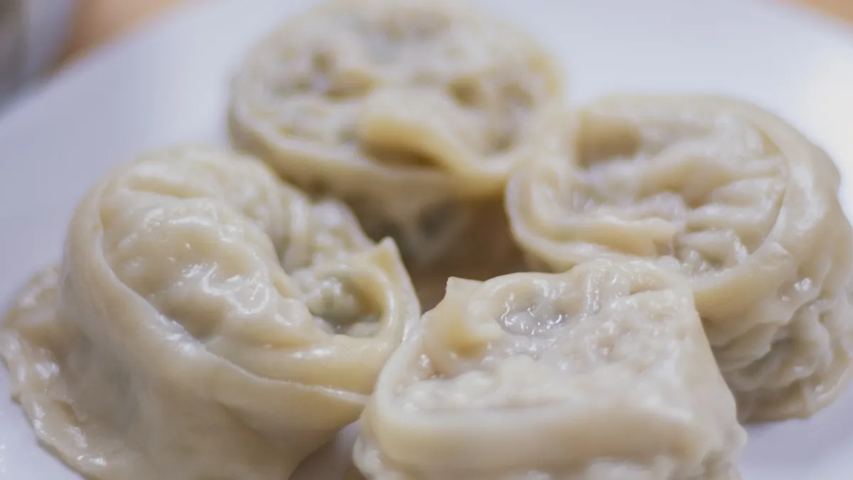 Plate of steamed Korean mandu dumplings folded into rounds