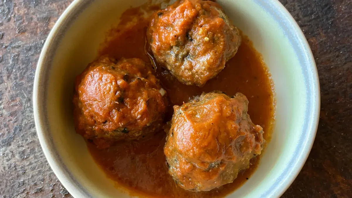 Sweet and sour meatballs in sauce in a white bowl