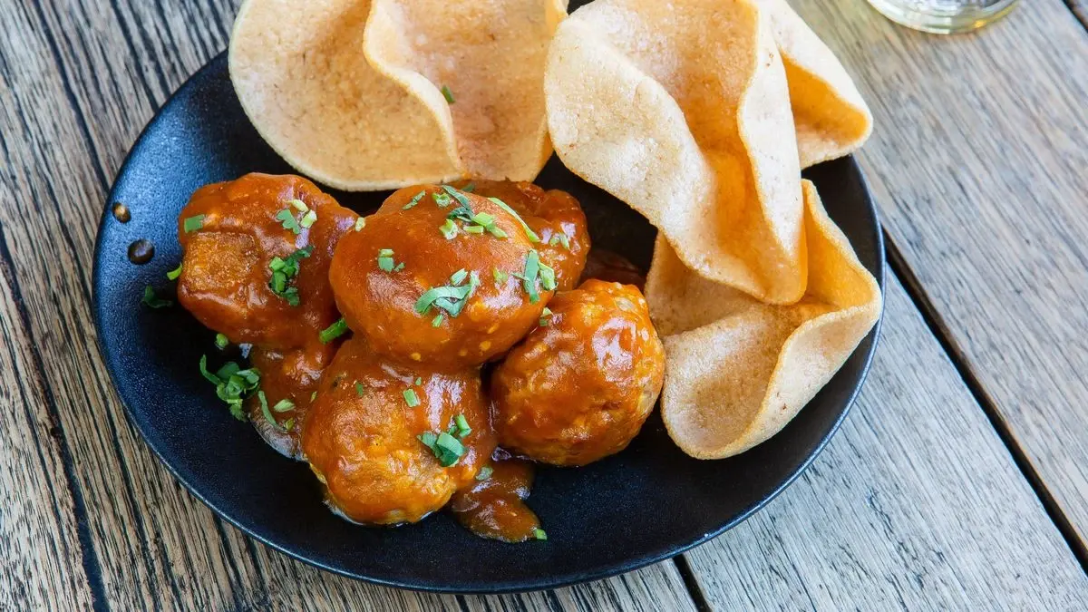 Meatballs in a sweet and sour glaze with shrimp chips